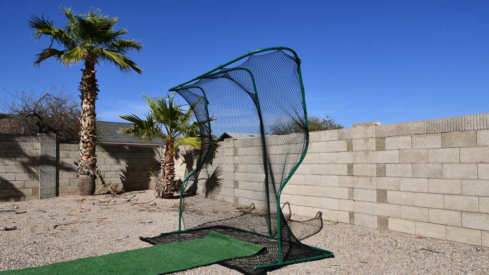 Golf net with roll of fresh lawn carpet