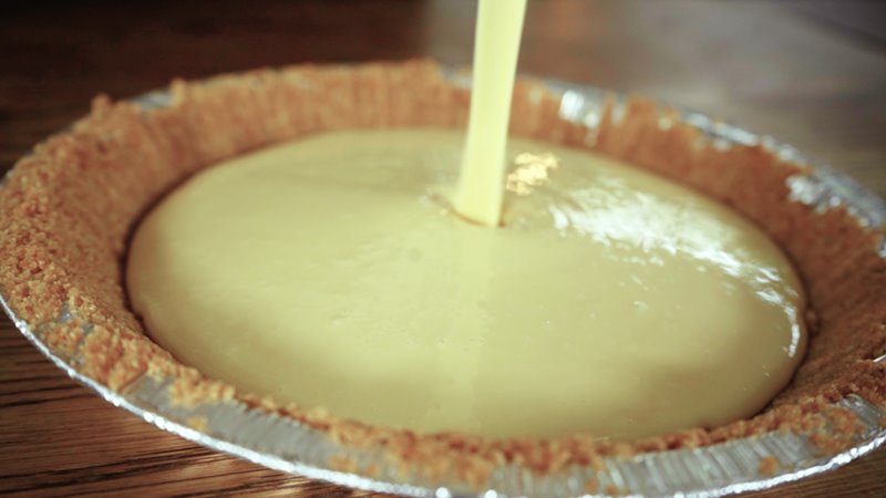 Key lime pie poured into graham cracker crust