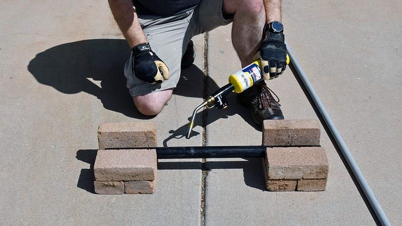 Stacked bricks and a piece of black pipe